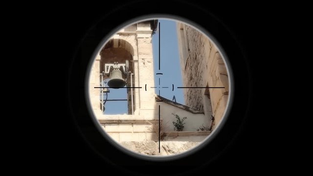 A sniper scope pointing at the belfry of a church. Reminiscent of spaghetti western movies.
