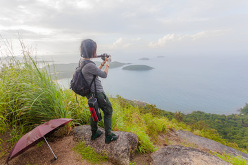 a women take photography on Pha Hin Dum the highest viewpoint. on Pha Hin Dum viewpoint can see around Phuket island. Niharn beach wind turbine Phomphep cape Rawai beach are in front of Pha Hin Dum