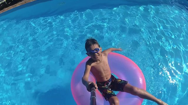 boy floats on an inflatable circle in the pool