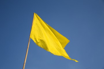 yellow flag on blue sky