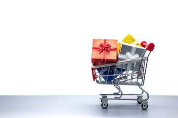 Shopping trolley with christmas gift on white background, copy space using for Christmas greeting card, New Year and happy birthday present decoration concept.