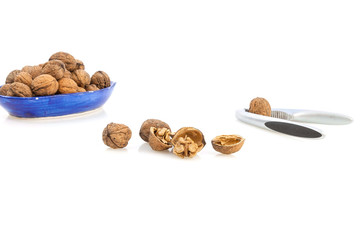 Isolated composition of healthy nuts, a nutcracker and a blue cup