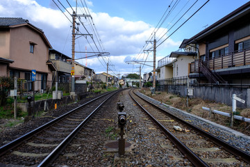 Fototapeta na wymiar Railroad tracks with Cityscape and cloudy sky in Japan