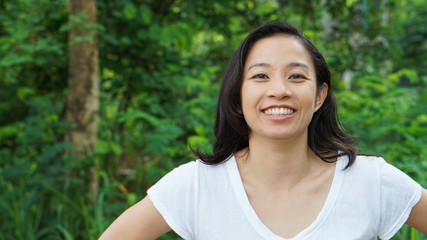 Asian woman long hair with facial epression green nature background