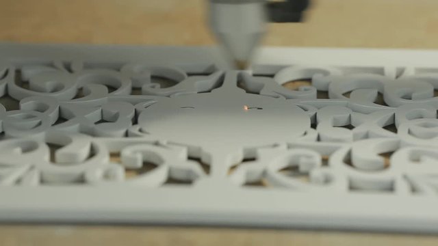  lose-up, a machine for laser engraving of a drawing on a wooden workpiece.