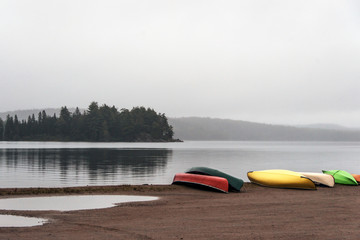 Canada Ontario Lake two rivers grey morning dark atmosphere Canoe Canoes parked beach water in...