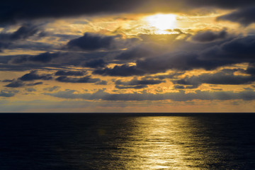 Stylized abstract landscape seascape sunset long exposure with clouds under different shades of blue, orange, yellow and red.