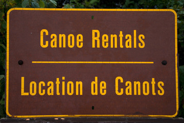 Canoes Rental sign written in english -french location de canots in Ontario algonquin national park canada for rent sign