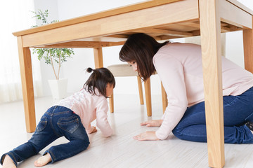 机の下に避難する親子
