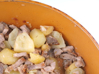 fried potatoes with meat in a frying pan