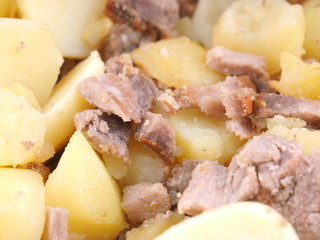 fried potatoes with meat in a frying pan