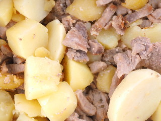 fried potatoes with meat in a frying pan