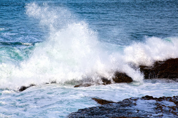 Sea waves crashing against the rocks .