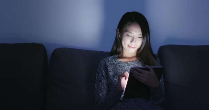 Woman use of digital tablet computer at home in night time