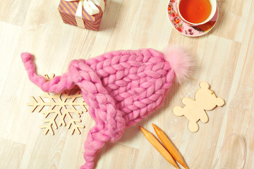 Handmade knitwear composition with warm hat of pastel color