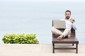 Businessman freelance on beach with laptop
