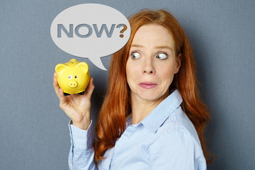 überraschte frau fragt ihr sparschwein etwas