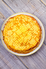 Stack of thin pancakes, crepes on white plate. View from above, top studio shot, vertical