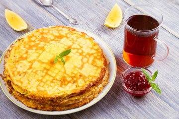 Stack of thin pancakes, crepes on white plate, horizontal