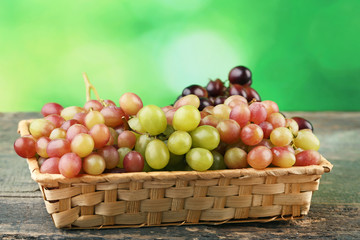 Grapes in basket on grey wooden table