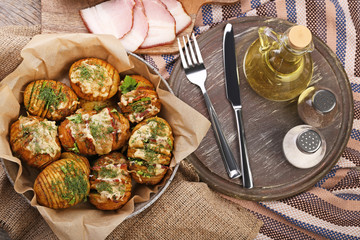 Baked potato with oil, salt and pepper on wooden table