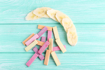 Different chewing gums with banana on mint background