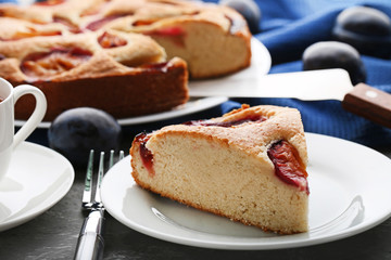 Sweet plum cake on grey wooden table