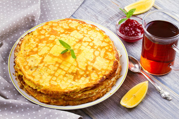 Stack of thin pancakes, crepes on white plate, horizontal