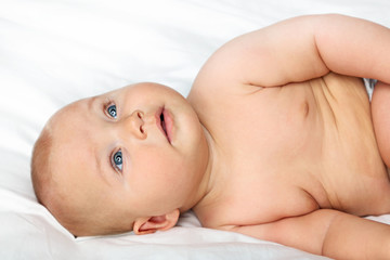 Little newborn baby on white bed