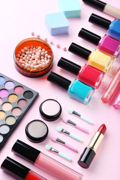 Different makeup cosmetics on a pink background