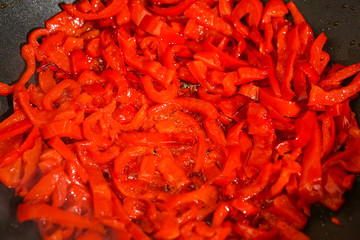 Preparation of cutted paprika in black frying pan