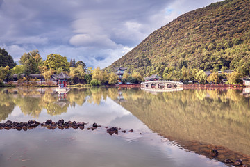 Vintage toned Suocui Bridge by the Black Dragon Pool in Jade Spring Park, located at the foot of Elephant Hill on the northern edge of the Lijiang Old Town, China.