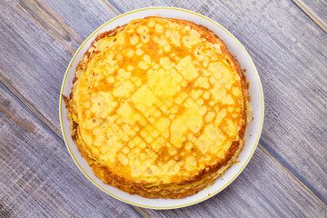 Stack of thin pancakes, crepes on white plate. View from above, top studio shot, horizontal