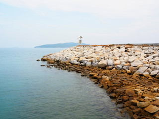 Rock coast with wooden lighthouse on the beach in Rayong, thailand