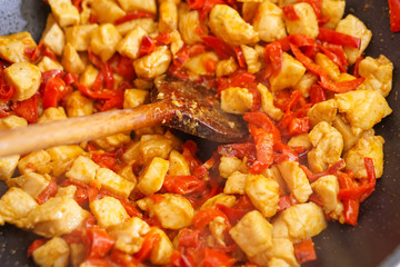 Preparation of cutted paprika with chicken meat in black frying pan