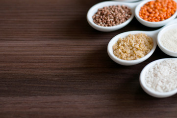Cereals in a white dish on a dark wooden background. Close-up with soft focus.