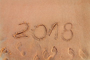 New Year written on sandy beach 2018 is coming  like date holiday concept