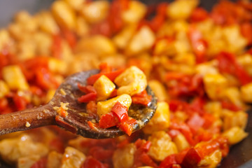Preparation of cutted paprika with chicken meat in black frying pan