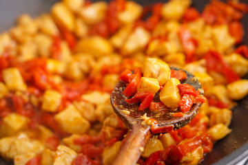 Preparation of cutted paprika with chicken meat in black frying pan