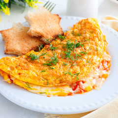Omelette with tomatoes and cheeses and toast, square