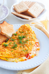 Breakfast with an omelette with tomatoes and cheese, tea and biscuits, selective focus