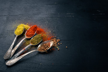 Spices and herbs. A large assortment of spices. Indian cuisine. On the wooden table. Top view. Free space for text.