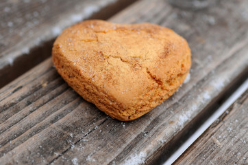 Homemade cookies with sugar and cinnamon in the form of hearts on a wooden background