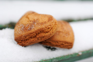 Homemade cookies with sugar and cinnamon in the form of hearts on a background of snow