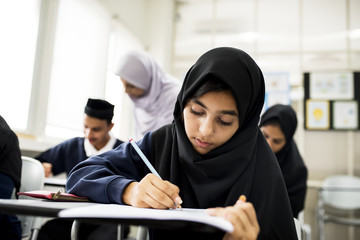 diverse muslim children studying in classroom