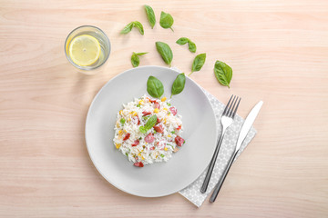 Plate with rice, sausage and vegetables on light background
