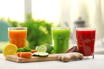Glasses with various fresh vegetable juices on table