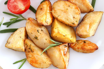 Delicious baked potatoes with rosemary on plate, closeup