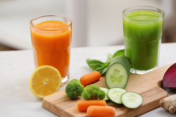 Glasses with various fresh vegetable juices on table