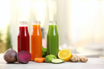 Bottles with various fresh vegetable juices on table